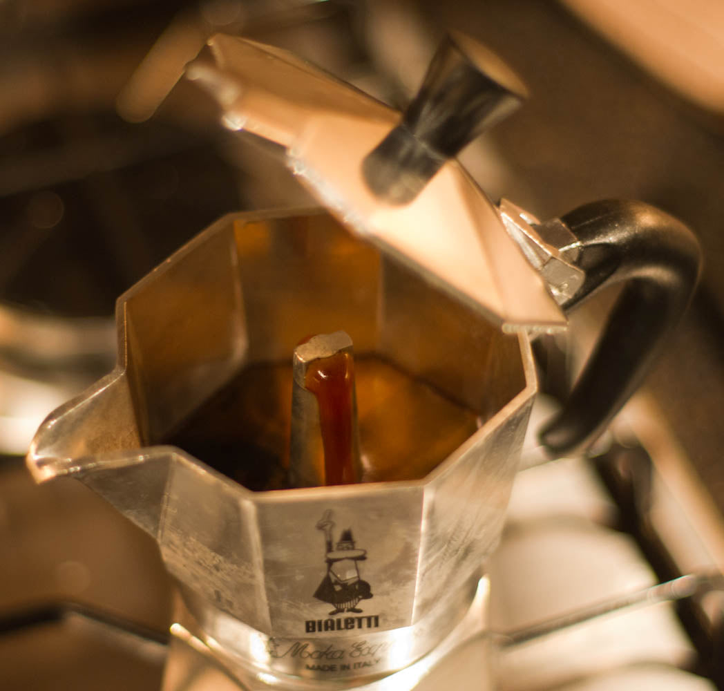 Café saliendo de una cafetera italiana durante la preparación